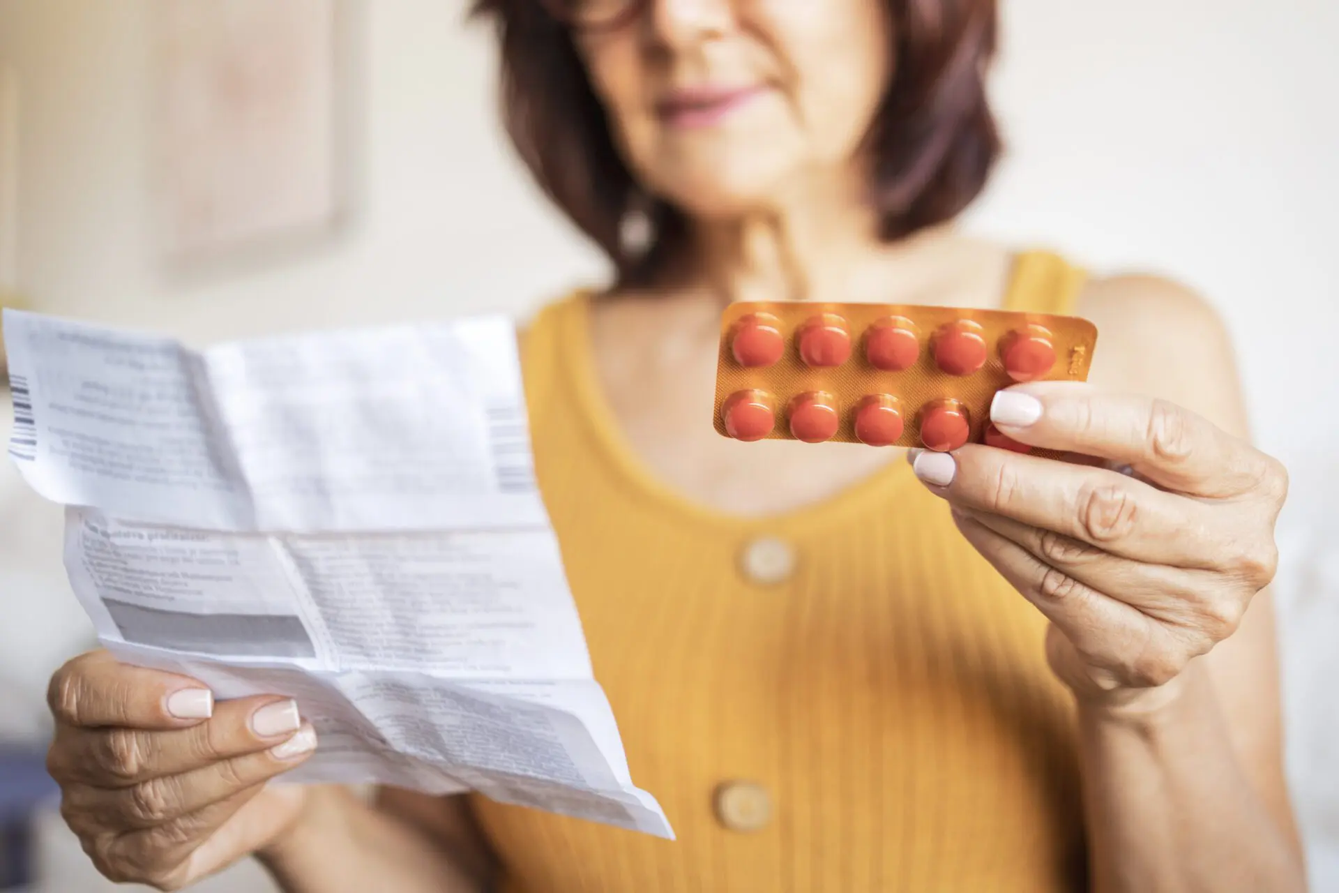 Close up of a woman checking patient information leaflet for her medicine. Image of a woman checking patient information leaflet for her medicine.