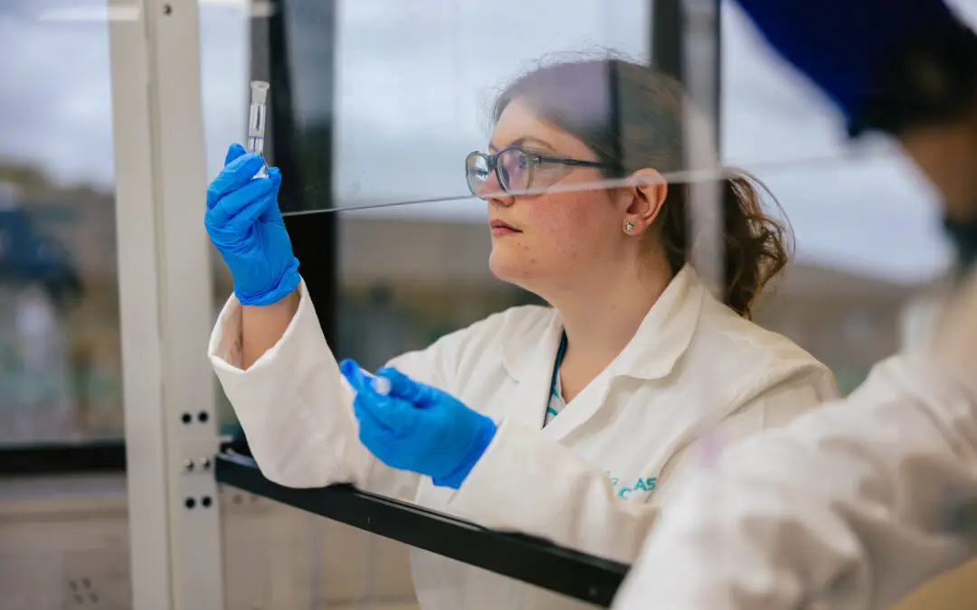 Image of a medical or scientific researcher looking at a clear solution in a laboratory